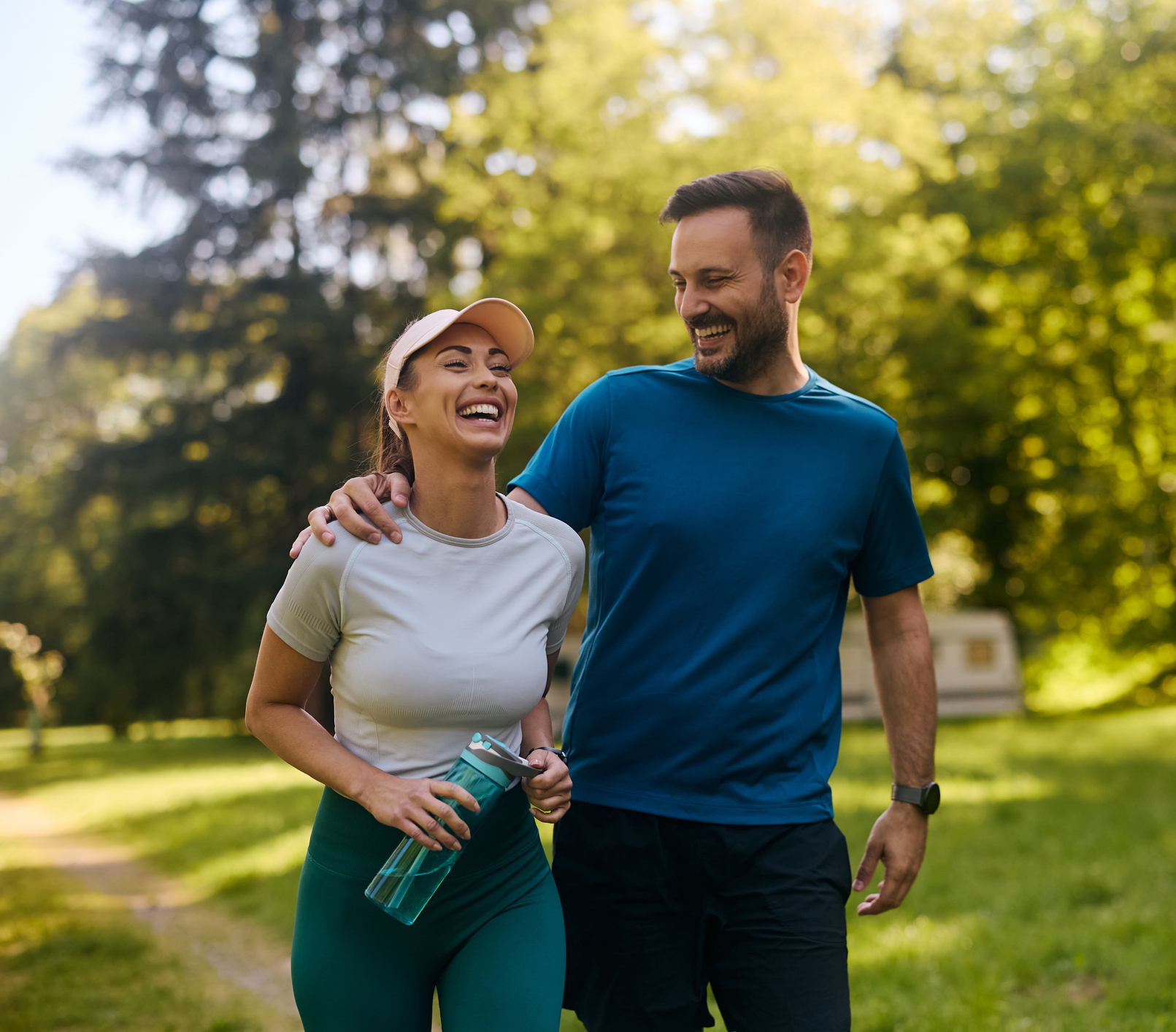 Happy couple laughing while working out in the park.